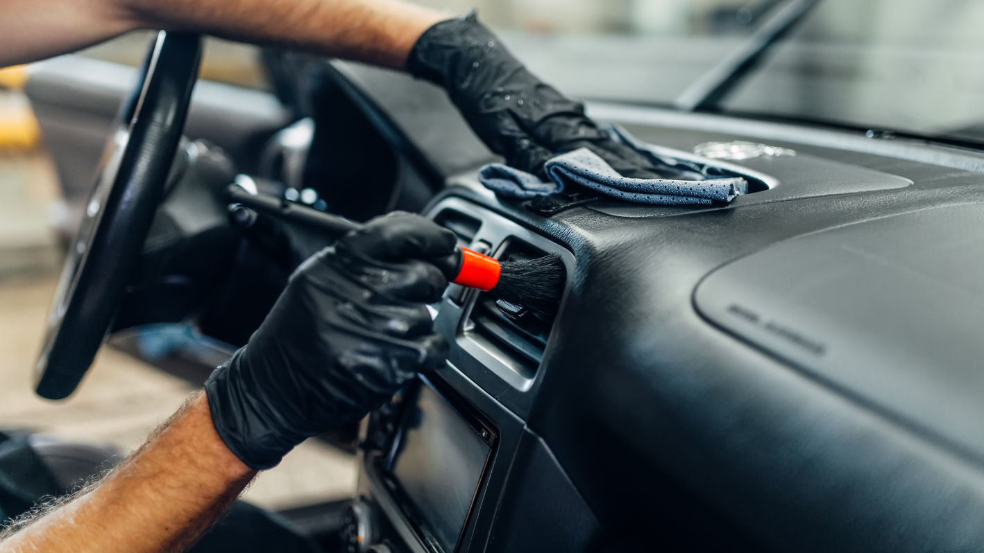 A man in black gloves and black gloves is driving a car