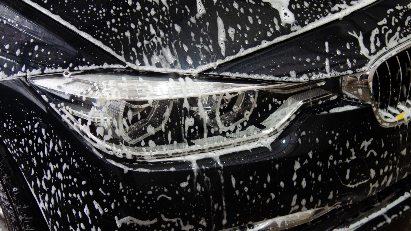 A close up of a car's headlight with water on it